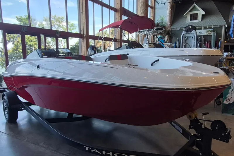 Slide: The Image of 2026 Tahoe T18 boat with red and white design displayed indoors. - 1