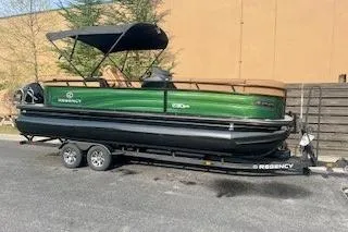 Slide: The Image of 2026 Regency 230 DL pontoon boat on trailer, featuring luxurious seating and sleek design. - 1