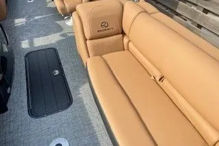 Slide: The Image of Top view of 2026 Regency 230 DL pontoon boat with brown seating and sleek design. - 6