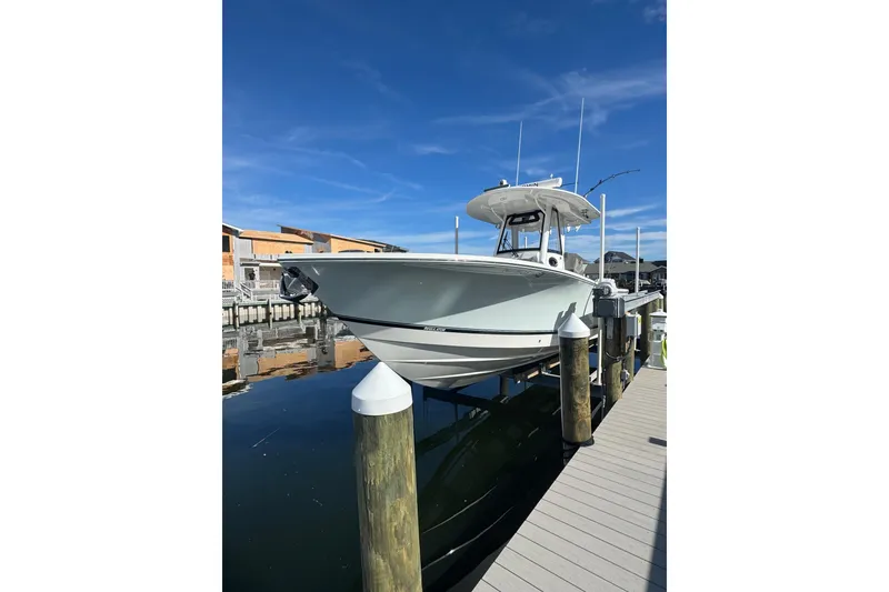 Slide: The Image of 2022 Regulator 28 Forward Seating boat docked under clear blue sky. - 1