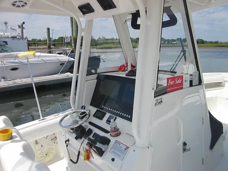Slide: The Image of 2023 Regulator 28 Forward Seating boat dashboard with "For Sale" sign at marina. - 5