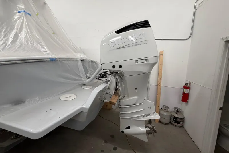 Slide: The Image of 1975 SeaCraft SC 23 Classic with Suzuki outboard motor in a workshop setting. - 13