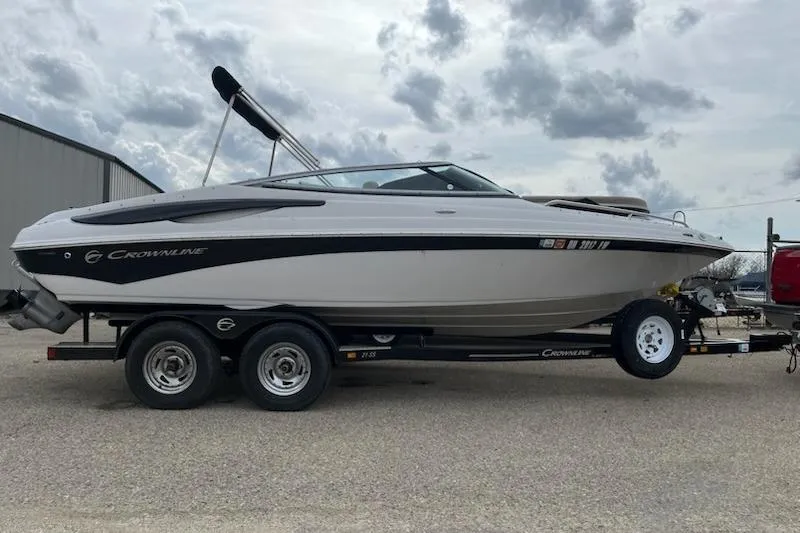The Image of 2011 Crownline 21 SS boat on trailer under cloudy sky. - 0