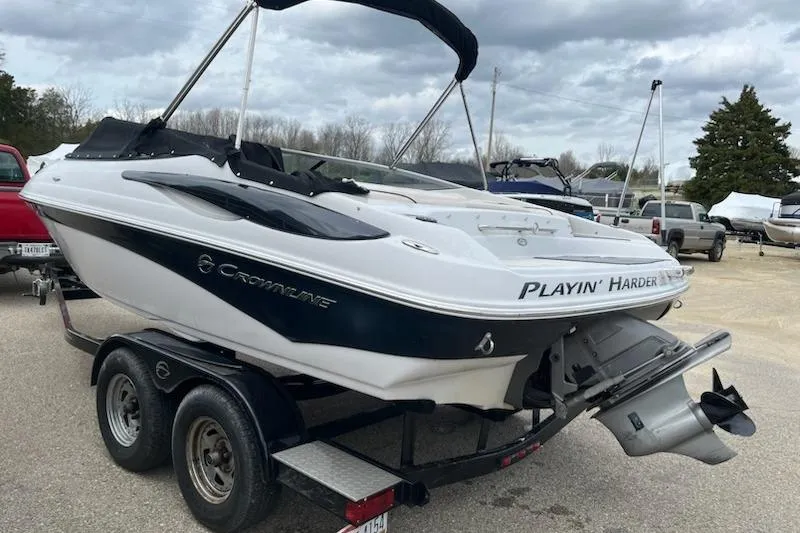 Slide: The Image of 2011 Crownline 21 SS boat on trailer, featuring "Playin' Harder" text on stern. - 2