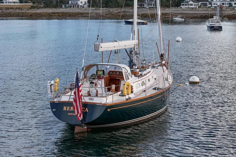 Slide: The Image of Hinckley Sou'wester 51 sailboat from 1989 anchored in a serene harbor setting. - 13