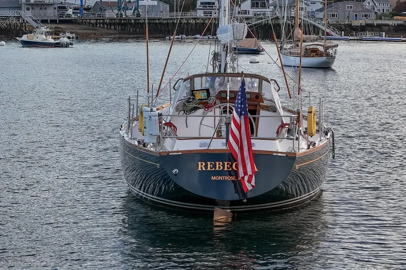 Slide: The Image of 1989 Hinckley Sou'wester 51 sailboat "Rebecca" docked with American flag displayed. - 14