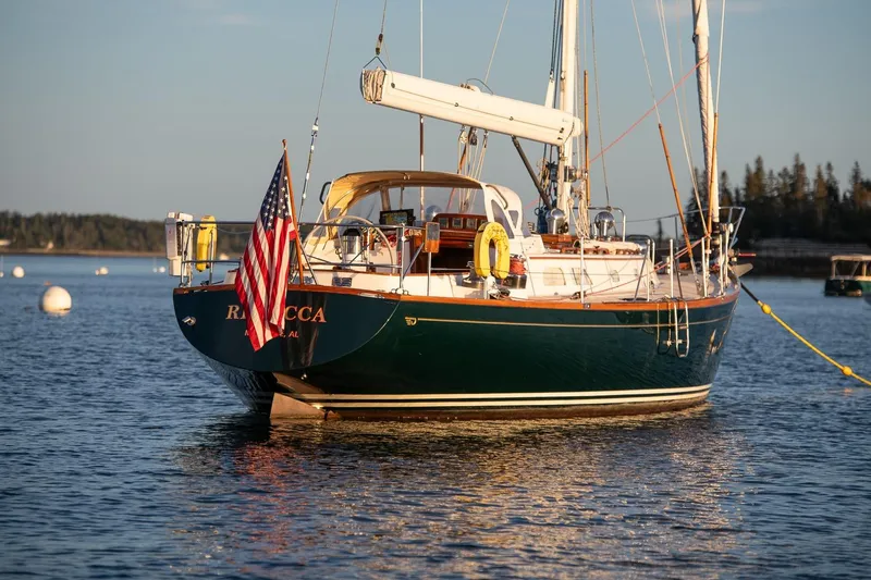 Slide: The Image of Hinckley Sou'wester 51 sailboat from 1989 anchored on calm water with American flag. - 15