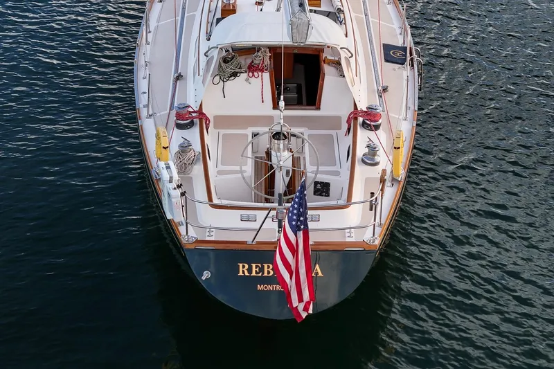 Slide: The Image of Hinckley Sou'wester 51 sailboat from 1989, docked with American flag, viewed from above. - 18