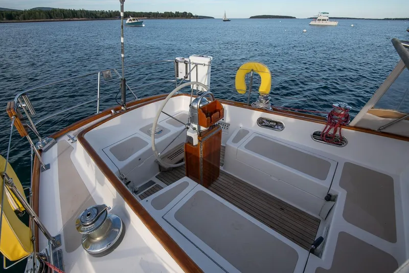 Slide: The Image of Cockpit of 1989 Hinckley Sou'wester 51 sailboat on calm water, featuring steering wheel and seating. - 28