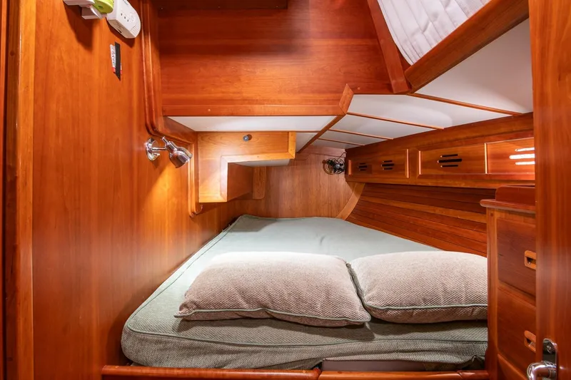 Slide: The Image of Cozy cabin interior of 1989 Hinckley Sou'wester 51 sailboat with wooden finish and bedding. - 41