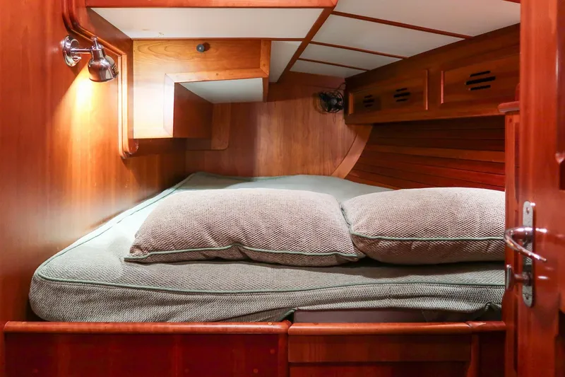 Slide: The Image of Cozy cabin interior of 1989 Hinckley Sou'wester 51 sailboat with wooden finish and bedding. - 42