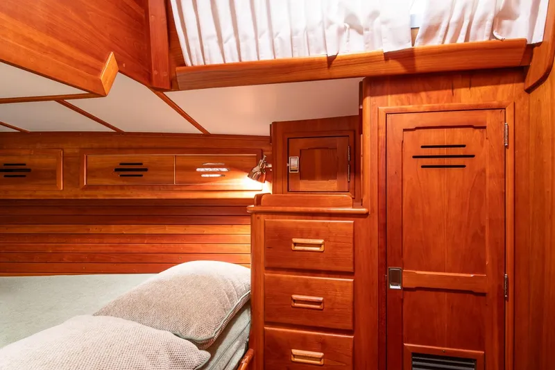 Slide: The Image of Hinckley Sou'wester 51 (1989) yacht interior with wooden cabinetry and cozy bedding. - 45