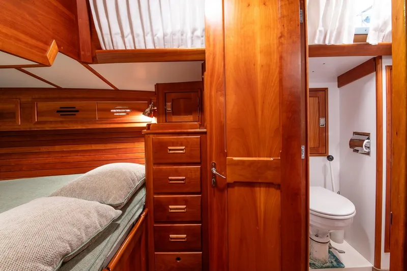 Slide: The Image of Hinckley Sou'wester 51 yacht interior, featuring wooden cabinetry, bed, and compact bathroom, 1989 model. - 47
