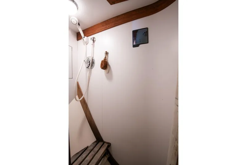 Slide: The Image of Shower area in 1989 Hinckley Sou'wester 51 yacht with wooden accents and showerhead. - 51