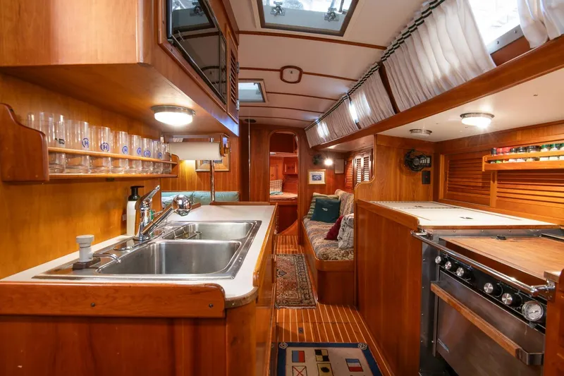 Slide: The Image of Luxurious 1989 Hinckley Sou'wester 51 yacht interior with wooden cabinetry and modern amenities. - 52