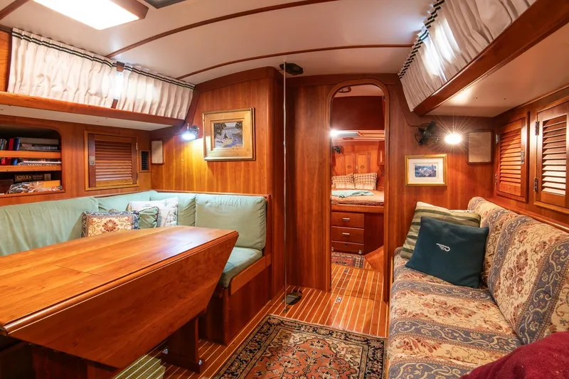 Slide: The Image of Cozy interior of 1989 Hinckley Sou'wester 51 sailboat with wood paneling and seating area. - 55