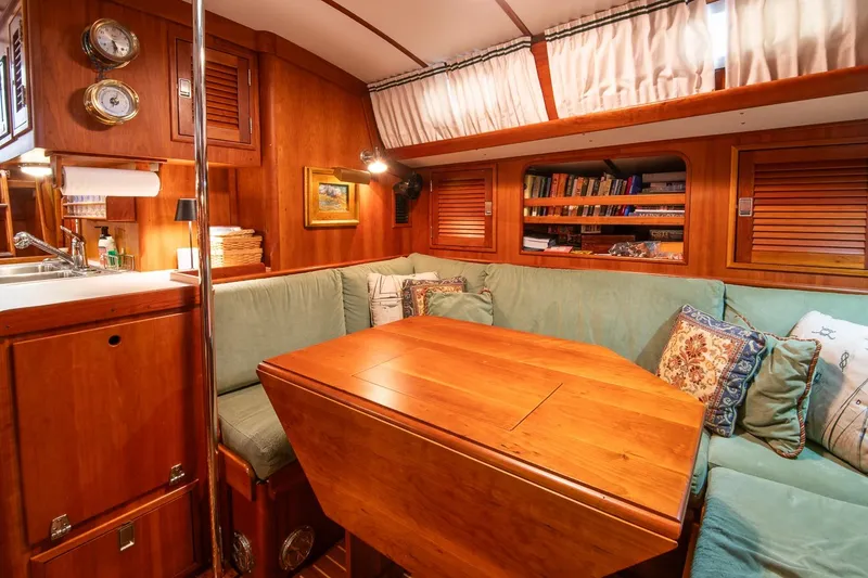 Slide: The Image of Cozy interior of 1989 Hinckley Sou'wester 51 yacht with wooden furnishings and cushioned seating. - 56