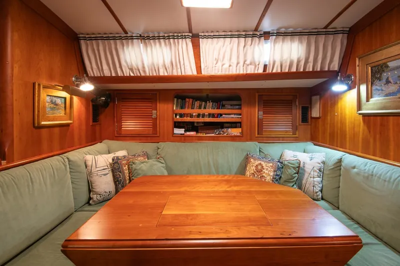 Slide: The Image of Cozy interior of 1989 Hinckley Sou'wester 51 yacht with wooden table and cushioned seating. - 57