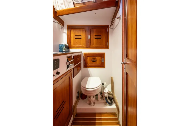 Slide: The Image of 1989 Hinckley Sou'wester 51 yacht bathroom with wooden cabinetry and marine toilet. - 67