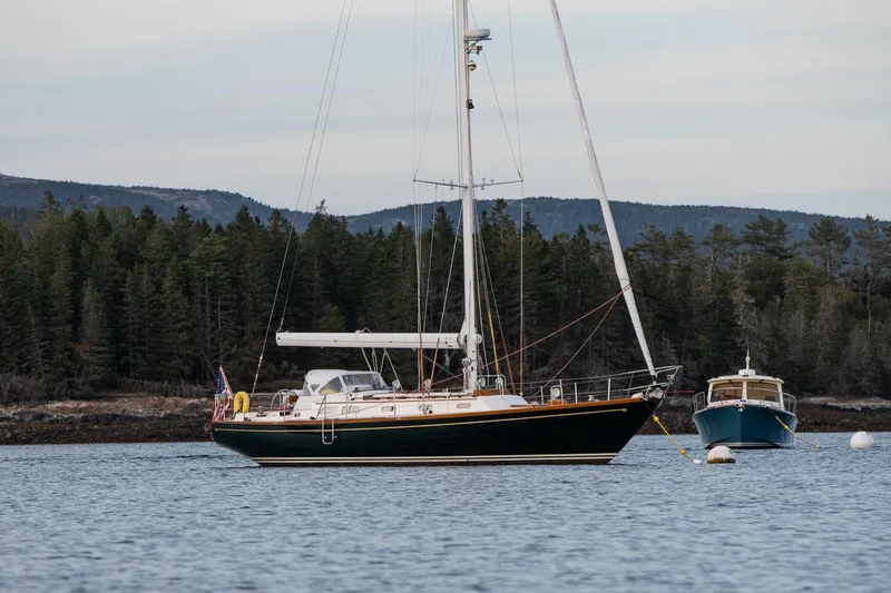 Slide: The Image of Hinckley Sou'wester 51 sailboat from 1989 anchored near a forested shoreline. - 71