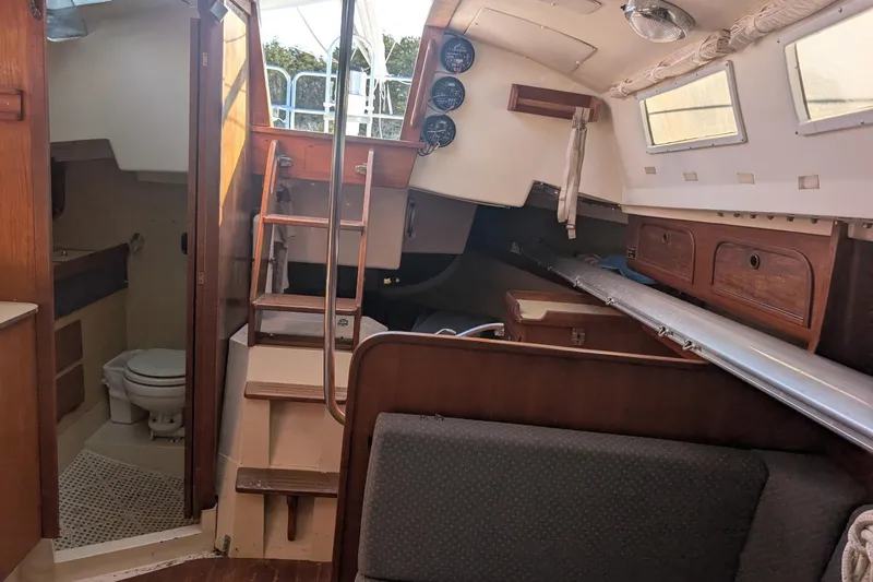Slide: The Image of Interior of a 1986 CAL 28 sailboat, featuring a cozy cabin with wooden accents. - 4
