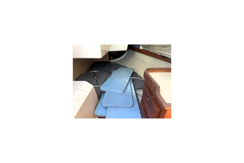 Slide: The Image of Interior of a 1986 CAL 28 sailboat with blue cushions and wooden cabinetry. - 7