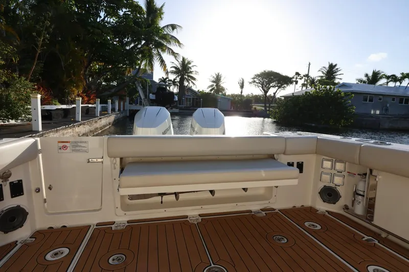Slide: The Image of 2025 Boston Whaler 325 Conquest boat interior with teak flooring and scenic waterfront view. - 13