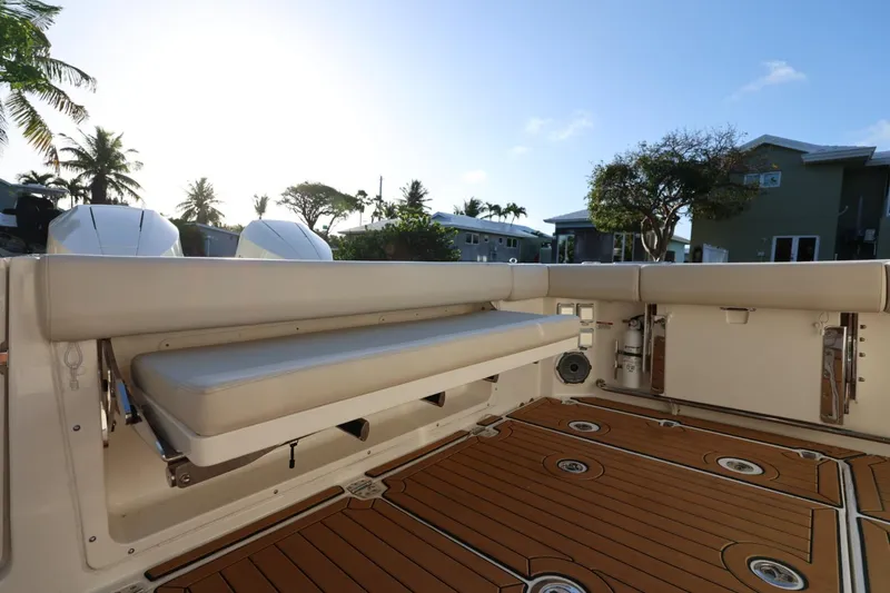 Slide: The Image of 2025 Boston Whaler 325 Conquest boat interior with cushioned seating and wooden deck. - 14