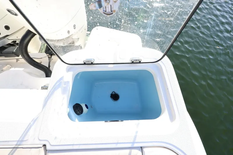 Slide: The Image of Livewell on 2025 Boston Whaler 325 Conquest boat, open lid, near water. - 18