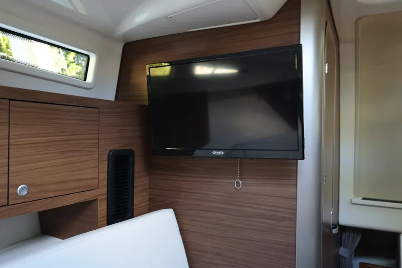 Slide: The Image of Interior of 2025 Boston Whaler 325 Conquest with mounted TV and wood paneling. - 28