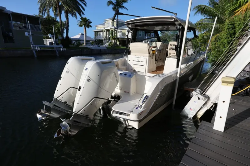 Slide: The Image of 2025 Boston Whaler 325 Conquest docked, featuring dual outboard engines and luxurious seating. - 3