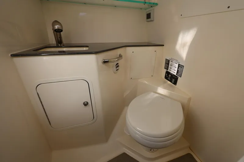 Slide: The Image of 2025 Boston Whaler 325 Conquest bathroom with sink and toilet, featuring modern design. - 31
