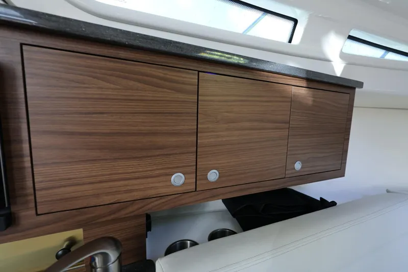 Slide: The Image of Interior cabinetry of 2025 Boston Whaler 325 Conquest, featuring sleek wooden finish and modern design. - 34