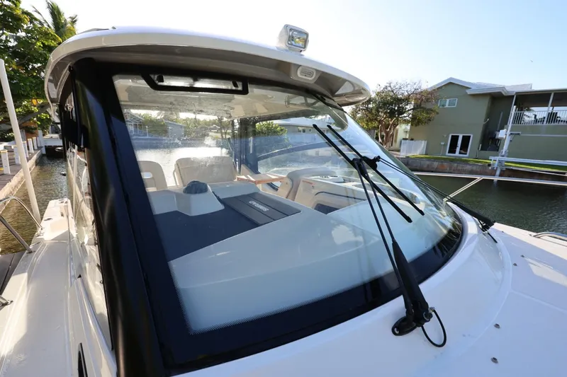 Slide: The Image of 2025 Boston Whaler 325 Conquest boat docked, showcasing sleek windshield design. - 38