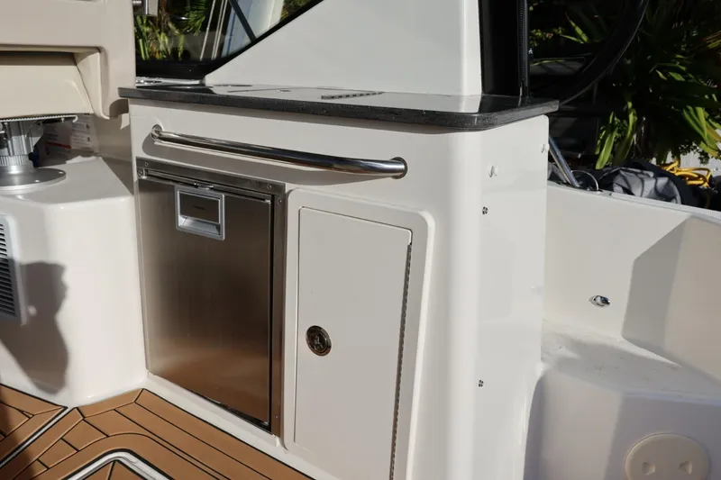 Slide: The Image of 2025 Boston Whaler 325 Conquest boat interior with stainless steel cabinetry and wood flooring. - 40
