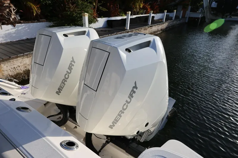 Slide: The Image of Twin Mercury outboard engines on a 2025 Boston Whaler 325 Conquest boat by the water. - 5