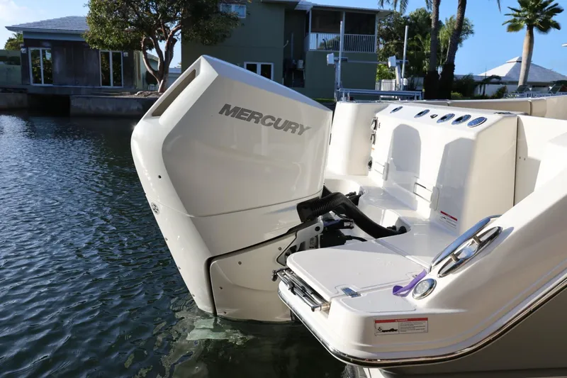 Slide: The Image of 2025 Boston Whaler 325 Conquest with Mercury engine, docked by waterfront homes. - 7