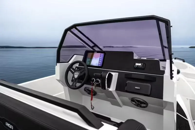 Slide: The Image of Manufacturer Provided Image: 2025 Iron 707 boat dashboard with steering wheel and navigation screen on calm water. - 15