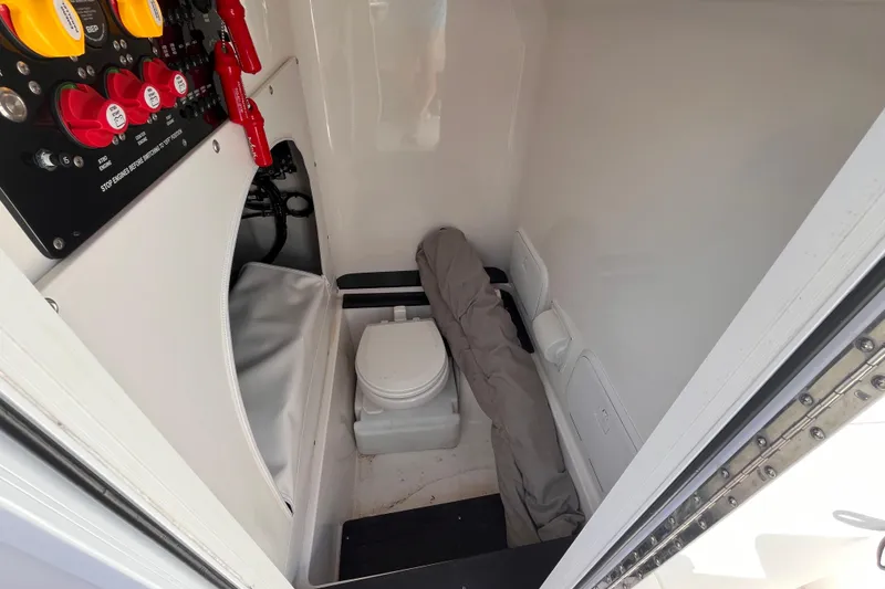 Slide: The Image of 2023 Fountain 38 Tournament Edition boat interior with control panel and compact toilet. - 15