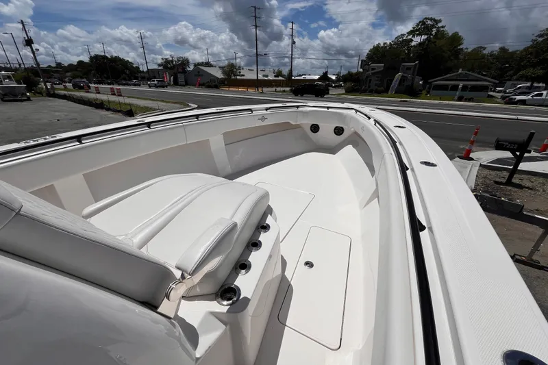 Slide: The Image of 2023 Fountain 38 Tournament Edition boat, spacious deck with seating, parked near a road. - 16