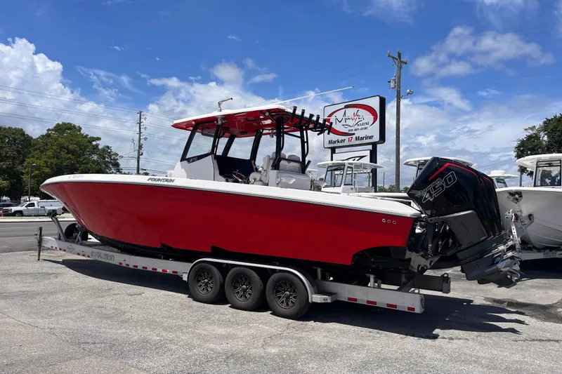 Slide: The Image of 2023 Fountain 38 Tournament Edition boat on trailer, red hull, parked outdoors. - 3