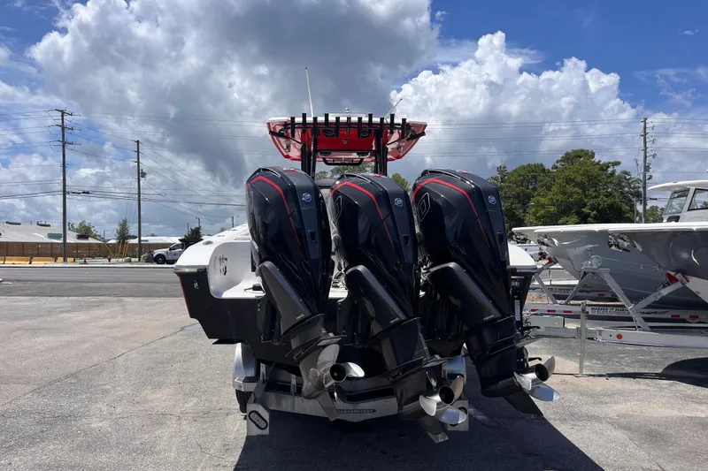 Slide: The Image of 2023 Fountain 38 Tournament Edition boat with triple outboard engines, parked outdoors. - 4