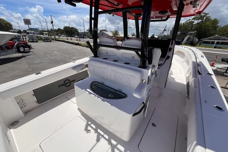 Slide: The Image of 2023 Fountain 38 Tournament Edition boat interior with seating and storage, parked outdoors. - 8