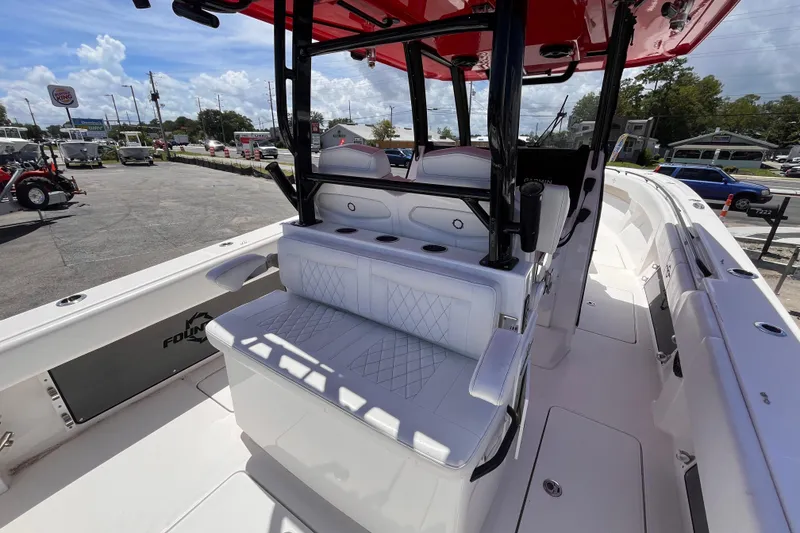 Slide: The Image of 2023 Fountain 38 Tournament Edition boat interior with seating and console, parked outdoors. - 9