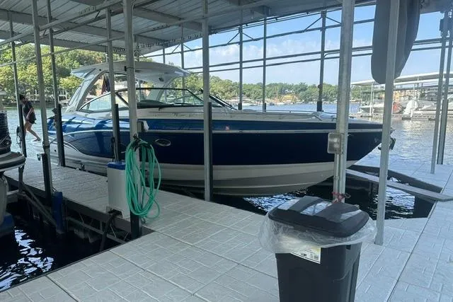 The Image of 2023 Formula 350 Crossover Bowrider I/O docked at a marina under a covered slip. - 0