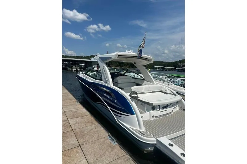 Slide: The Image of 2023 Formula 350 Crossover Bowrider I/O docked under a clear blue sky. - 10