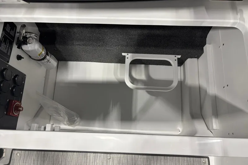 Slide: The Image of Storage compartment in 2026 Cobalt R6 boat with fire extinguisher and control panel. - 21