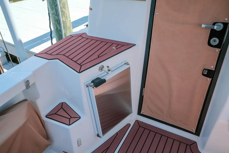Slide: The Image of 2024 FML R27 LE boat deck with wood accents and door. - 10