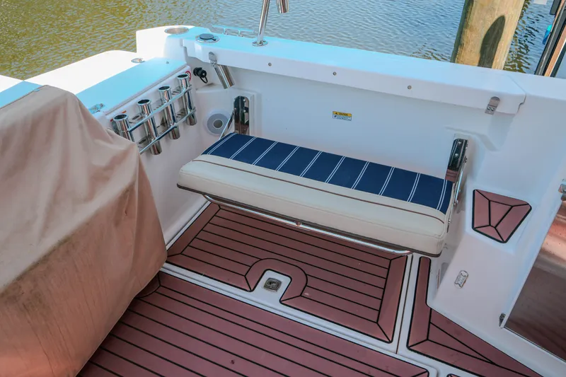 Slide: The Image of 2024 FML R27 LE boat with striped seating and rod holders on deck. - 13