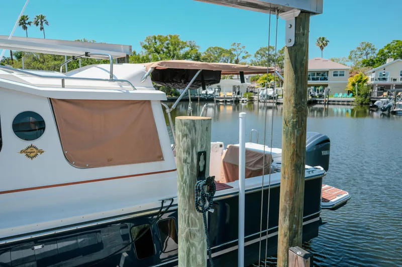 Slide: The Image of 2024 FML R27 LE boat docked by a serene waterfront with lush greenery. - 17